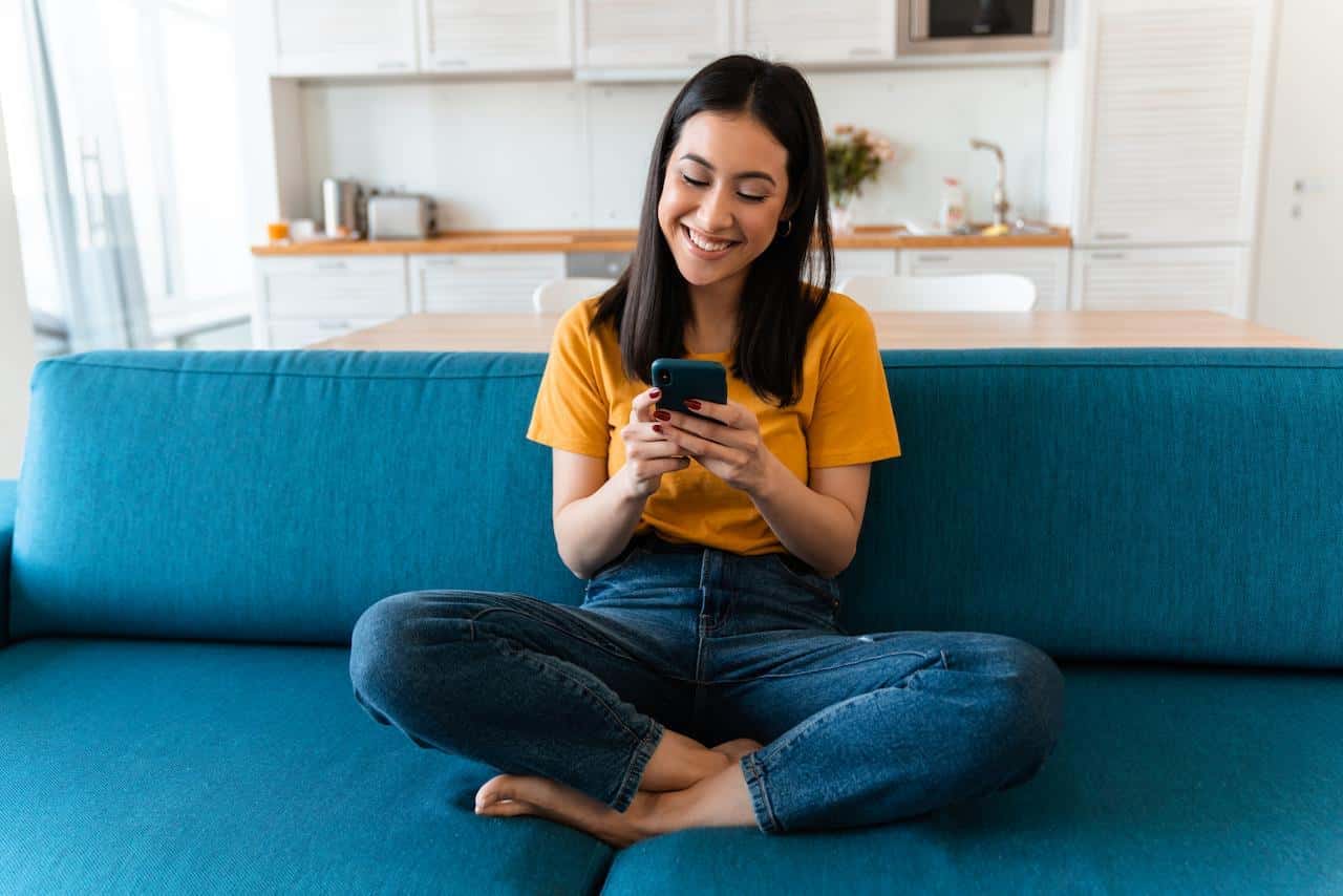 Una mujer sonriente usando su celular