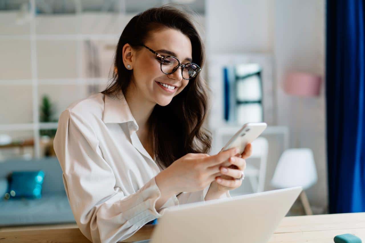 Una mujer usa la aplicación BanCoppel para conocer los requisitos de la Tarjeta de Crédito Oro